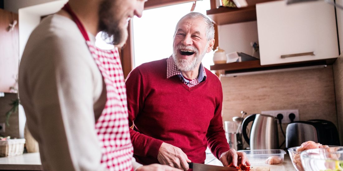 Hipster son with his senior father cooking in the kitchen. Hipster son with his senior father cooking in the kitchen. Two generations indoors.